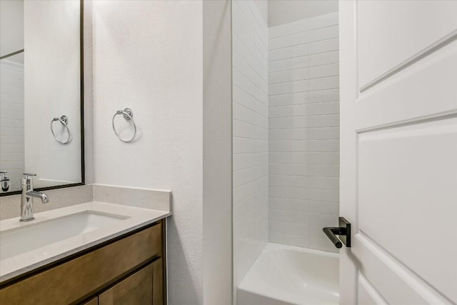 bathroom featuring tiled shower / bath and vanity