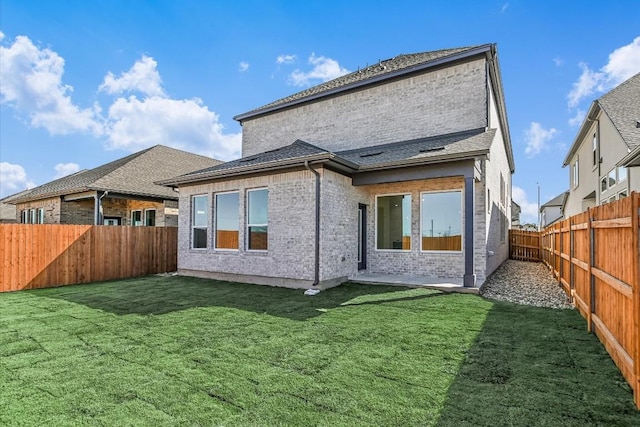 rear view of property with a yard