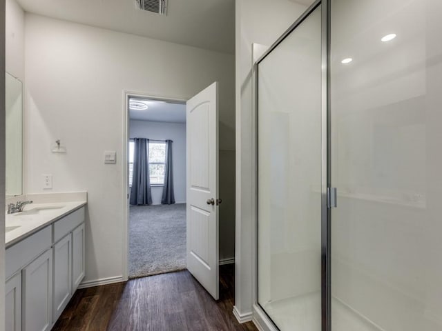 bathroom featuring vanity, wood-type flooring, and walk in shower