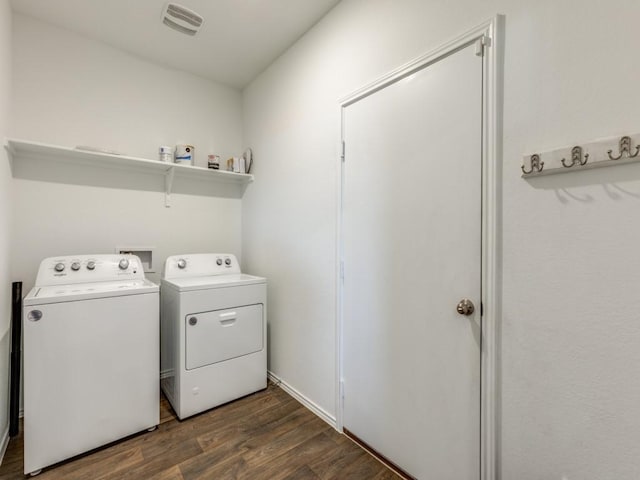 clothes washing area with dark hardwood / wood-style floors and washing machine and dryer