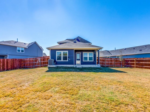 rear view of property featuring a yard, central AC, and a patio area