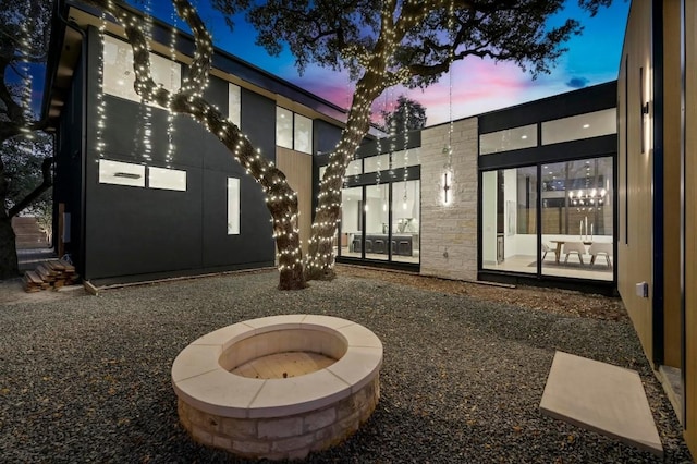 patio terrace at dusk featuring a fire pit