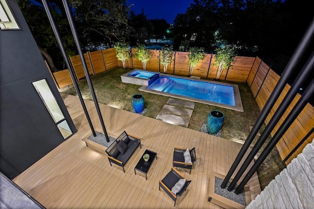 2423 S 5th St, Austin, TX 78704 - pool at night featuring a wooden deck, a fenced backyard, and an in-ground hot tub