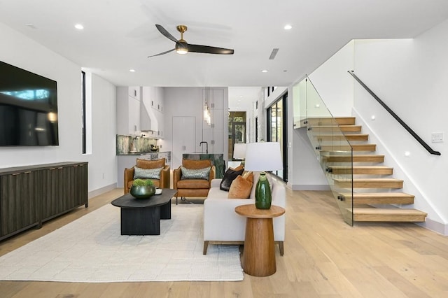 living room featuring ceiling fan and light wood-type flooring