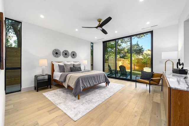 bedroom with ceiling fan, floor to ceiling windows, light hardwood / wood-style flooring, and multiple windows