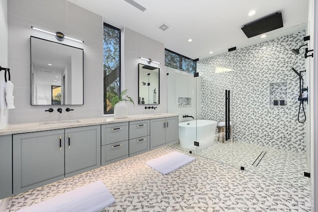 bathroom featuring vanity, tile walls, and shower with separate bathtub