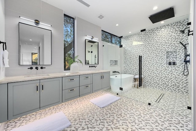 2423 S 5th St, Austin, TX 78704 - bathroom featuring a stall shower, double vanity, a freestanding tub, healthy amount of natural light, and tile walls
