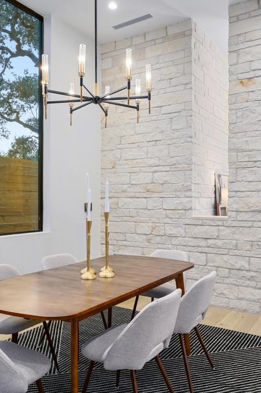 dining space with hardwood / wood-style flooring and an inviting chandelier