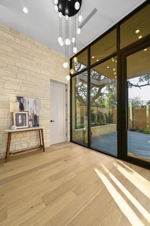 2423 S 5th St, Austin, TX 78704 - unfurnished dining area with expansive windows, a chandelier, and wood finished floors