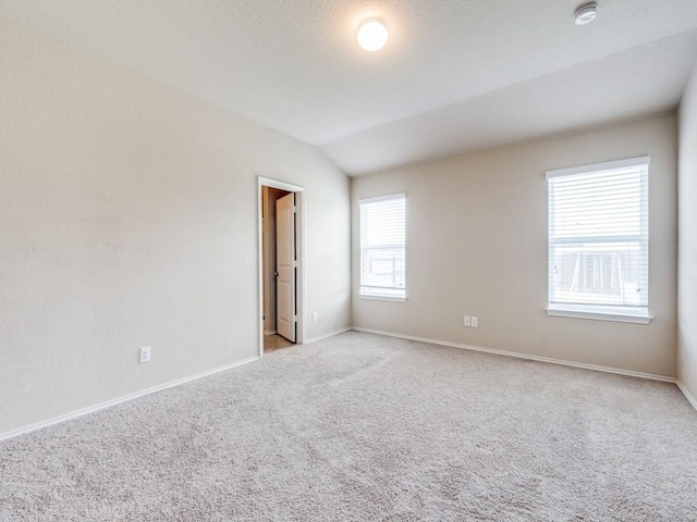 unfurnished room with light carpet and lofted ceiling