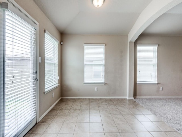 tiled spare room with lofted ceiling