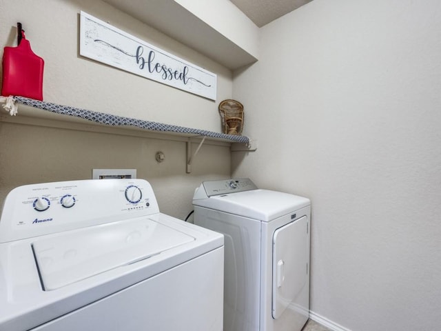 clothes washing area with washing machine and dryer