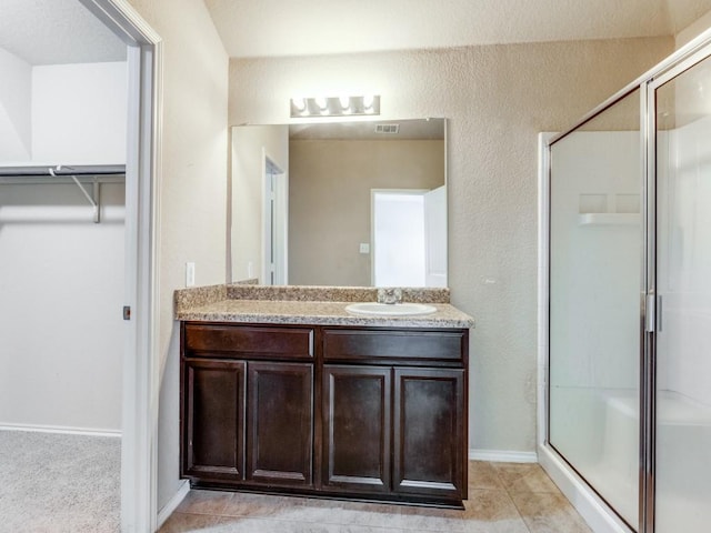 bathroom with tile patterned floors, vanity, and a shower with shower door