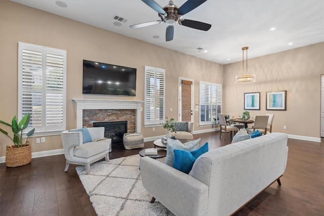 living room with a stone fireplace, ceiling fan, and hardwood / wood-style flooring