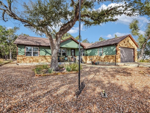 ranch-style home with a porch and a garage