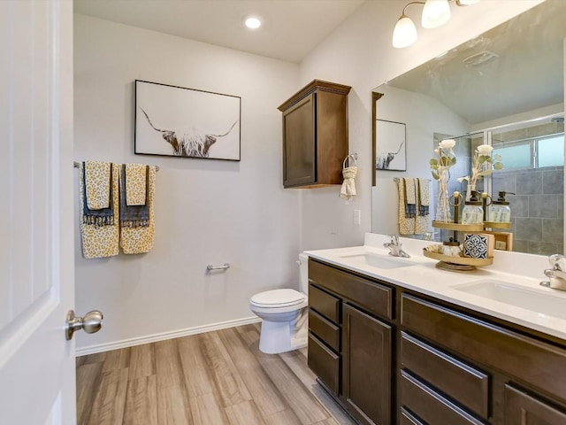 1640 T H Johnson Dr, Taylor, TX 76574 - full bathroom with wood finished floors, double vanity, and tiled shower
