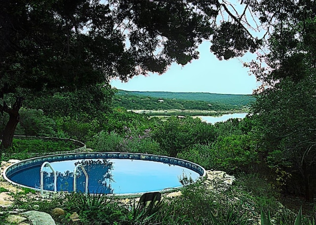 view of pool featuring a water view