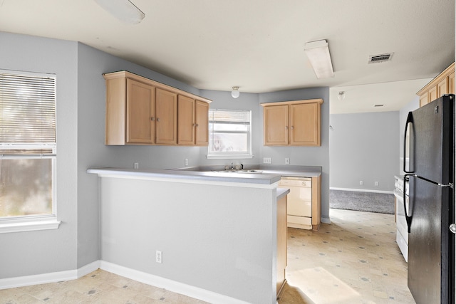 kitchen with light brown cabinets, kitchen peninsula, and white appliances