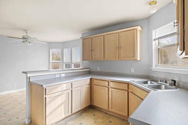 kitchen with light brown cabinets, ceiling fan, kitchen peninsula, and sink