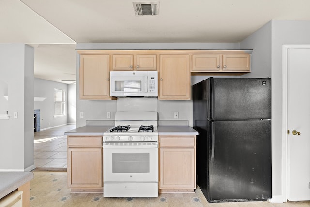 kitchen with white appliances and light brown cabinets