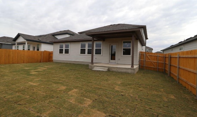 back of house with a lawn and a patio