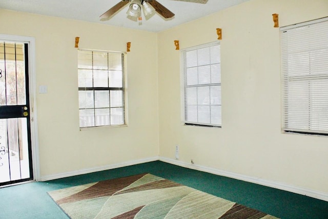 carpeted spare room featuring ceiling fan and a healthy amount of sunlight