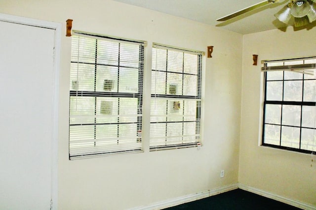 unfurnished room featuring ceiling fan and a healthy amount of sunlight