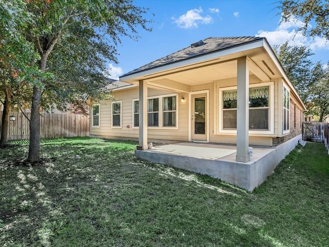 back of property with a lawn and a patio