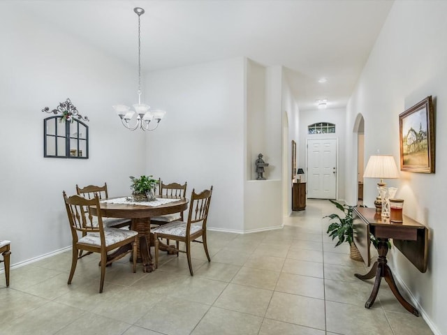 dining space featuring light tile patterned flooring and a notable chandelier