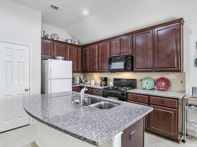 kitchen with sink, a kitchen island with sink, lofted ceiling, decorative backsplash, and black appliances