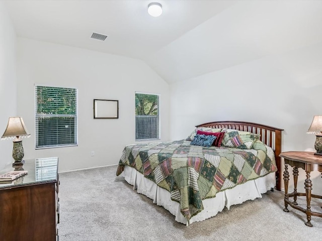 bedroom featuring light colored carpet, vaulted ceiling, and multiple windows