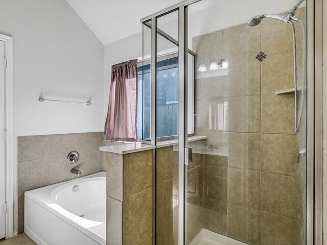 bathroom featuring shower with separate bathtub and lofted ceiling