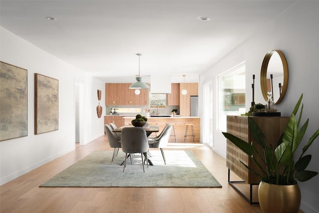 dining area with light wood-style flooring and baseboards