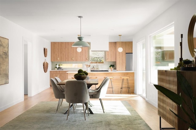 dining room featuring light wood-style flooring and baseboards