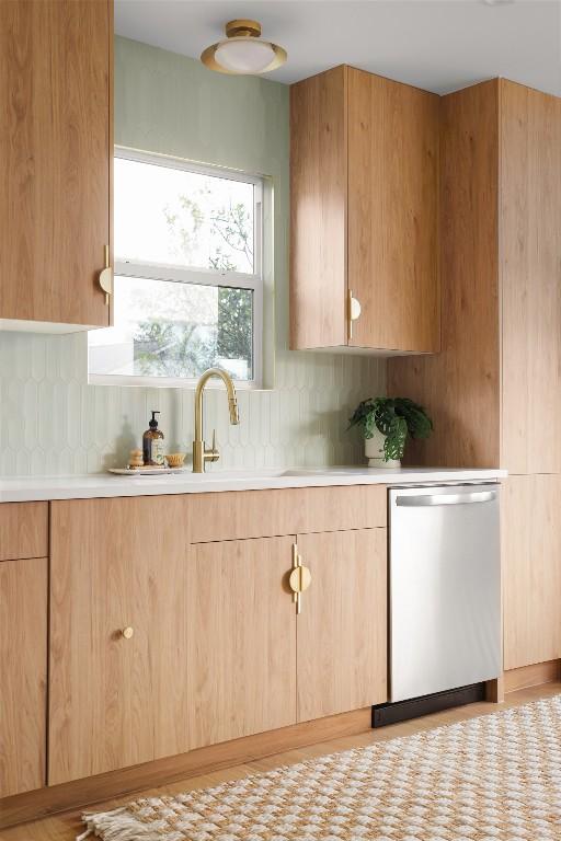 kitchen with dishwasher, sink, light brown cabinets, and decorative backsplash