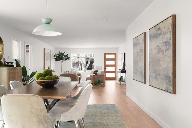 dining area with light wood-style floors and baseboards