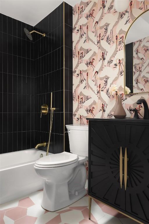 bathroom featuring tiled shower / bath combo and toilet