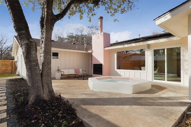 view of patio / terrace with an outdoor living space, fence, and a hot tub