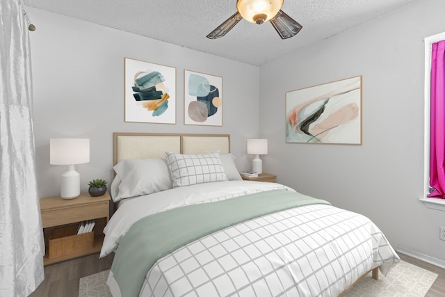 bedroom featuring hardwood / wood-style floors, a textured ceiling, and ceiling fan