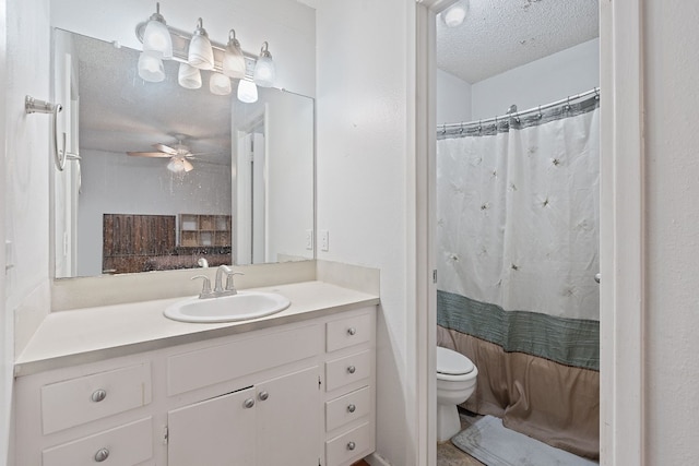 bathroom with vanity, a textured ceiling, ceiling fan, toilet, and curtained shower