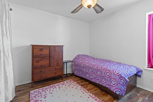 bedroom with ceiling fan, dark hardwood / wood-style flooring, and a textured ceiling