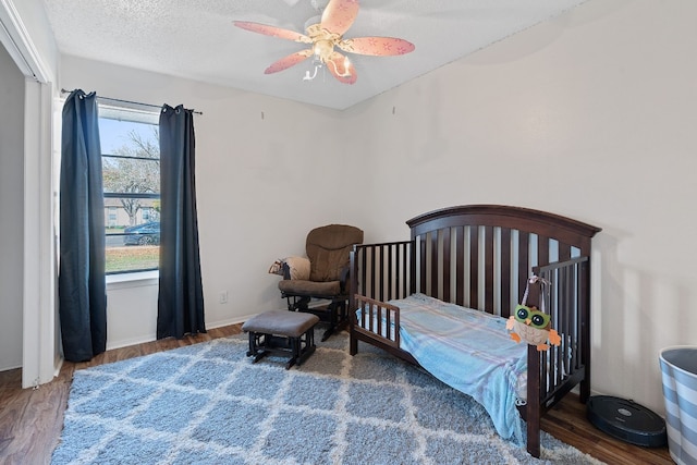 bedroom featuring ceiling fan, dark hardwood / wood-style flooring, and a textured ceiling