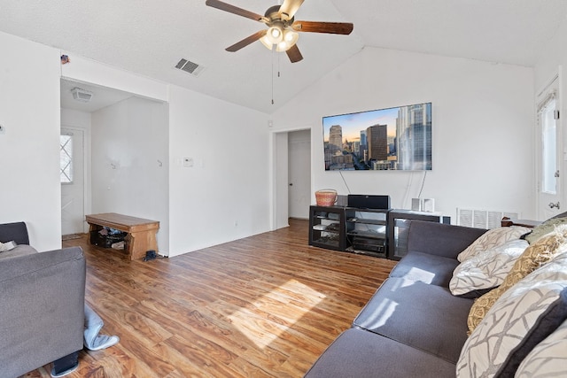 living room with hardwood / wood-style flooring, ceiling fan, and vaulted ceiling