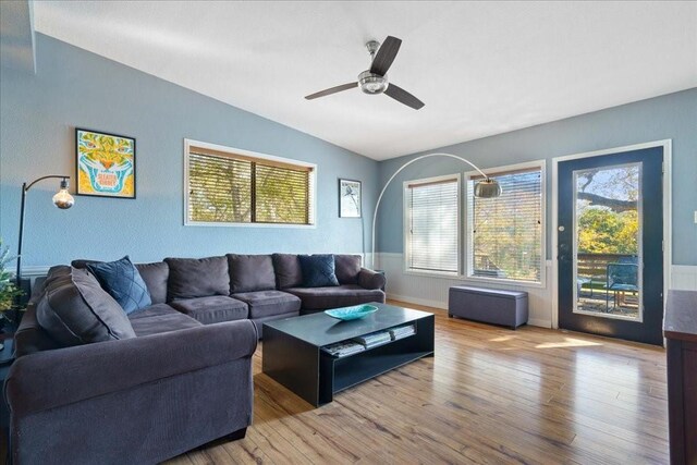 living room with hardwood / wood-style floors, vaulted ceiling, plenty of natural light, and ceiling fan