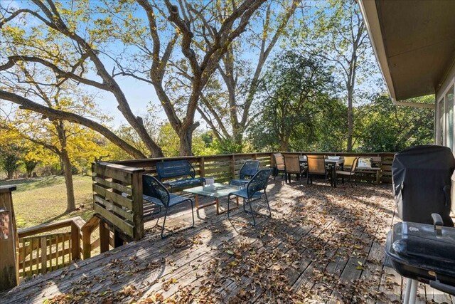 wooden terrace featuring an outdoor living space and area for grilling