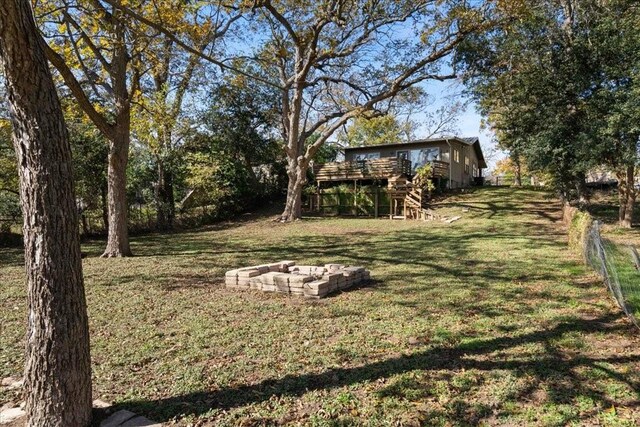 view of yard featuring a deck and an outdoor fire pit