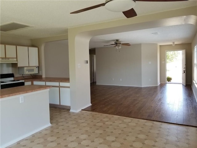 kitchen featuring white cabinets, light hardwood / wood-style floors, white appliances, and a textured ceiling