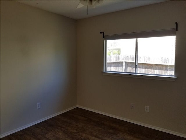 empty room with ceiling fan and dark hardwood / wood-style flooring