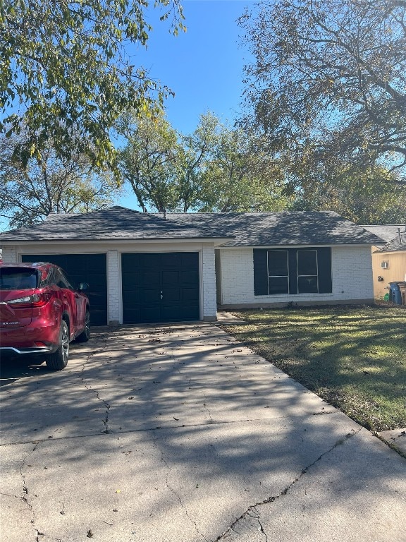 single story home with a garage and a front lawn