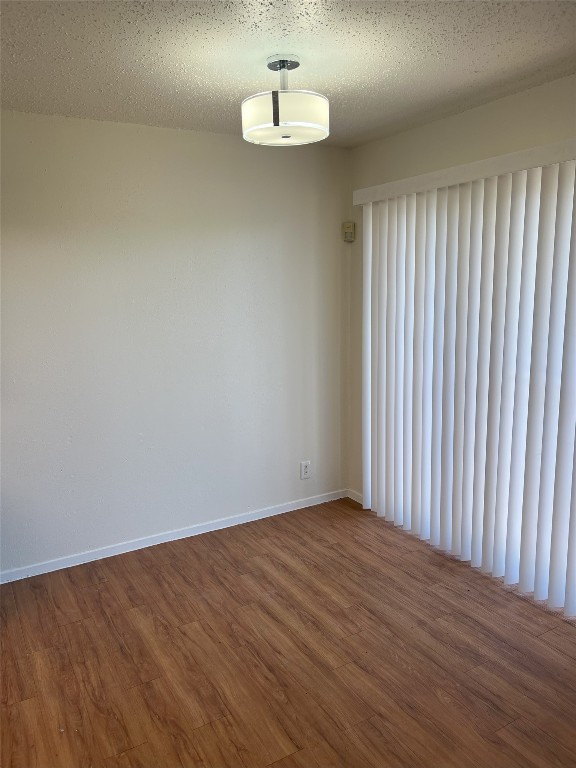 spare room with wood-type flooring and a textured ceiling